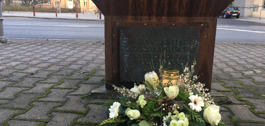 Weißes Blumengesteck am Fuße des Jüdischen Denkmals.