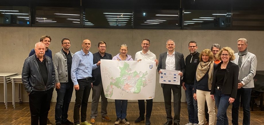 Gruppenfoto der Teilnehmenden der Projektstartsitzung im Wilhelmjsalon. Auf dem Foto von links nach rechts zu sehen sind: 1. Herr Keth (FDP)  2. Herr Wippern (Hansa Luftbild)  3. Herr Wagenbach (Klimaschutzmanager Stadt Usingen)  4. Herr Dr. Stampfl (Telesis)  5. Herr Bornath (Mainova)  6. Frau Müller (SPD)  7. Herr Bienias (Syna)  8. Herr Bürgermeister Steffen Wernard  9. Herr Brötz, (FWG, Fraktionsvorsitzender)  10. Frau Bertz (CDU)  11. Herr Guth (Stadt Usingen)  12. Frau Pöhlmann (Stadt Usingen)  13. Herr Lindeman-Elbertzhagen (Mainova)